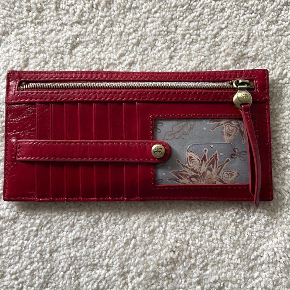 Slim wallet. 13 pockets, 1 clear slot. Zippered coin pouch and snap enclosure.